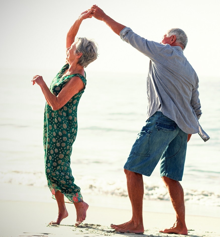 an older couple dances on the beach